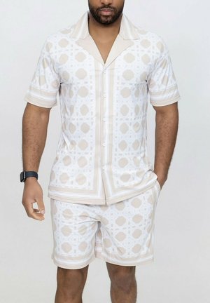 Ensemble chemise à manches courtes et short en crème avec des motifs géométriques blancs. Fabriqué en tissu léger, avec des rayures contrastantes.