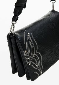 Borsa a tracolla nera in pelle con superficie testurizzata, caratterizzata da motivi floreali ricamati in bianco e accenti in metallo argentato. Tracolla regolabile.