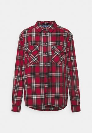 Chemise en flanelle à carreaux rouge et noir avec un devant à boutons, deux poches poitrine et un col classique. Matériau en coton avec une texture douce.