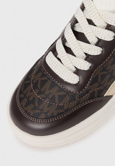 Brun sneaker med mönstrad tyg som har en geometrisk design, ljusa snören, texturerade läderdetaljer och en tjock vit sula.