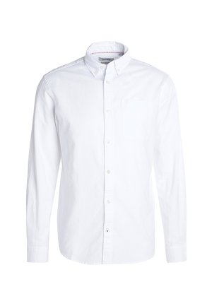 Chemise blanche à manches longues avec col boutonné et poche poitrine, présentée sur un fond blanc uni.