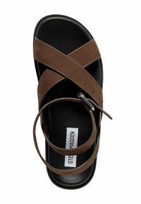 Sandale en daim marron avec de larges brides entrecroisées, semelle noire et une sangle pour la cheville avec une boucle. Présente une étiquette avec "STEVE MADDEN".