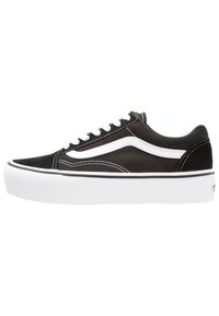 Black canvas sneaker with white rubber sole, featuring white side stripe, lace-up design, and contrasting stitching. Classic low-profile shape.