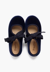 Zapatos de ballet de terciopelo azul marino con punta redonda, lados recortados y lazos de cinta negra. El interior presenta una plantilla marrón claro con la marca.