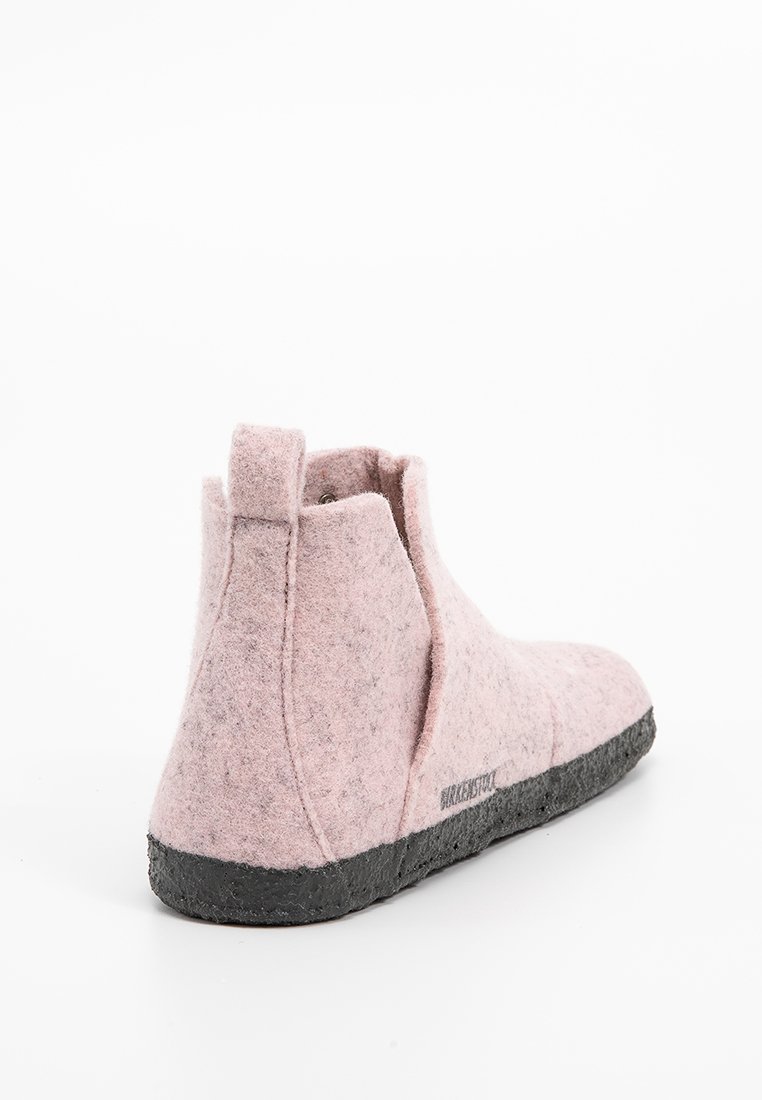 Rosa Filz-Ankle-Boots mit glatter Textur, schwarzer Gummisohle und minimalen Nähten für ein modernes Design.