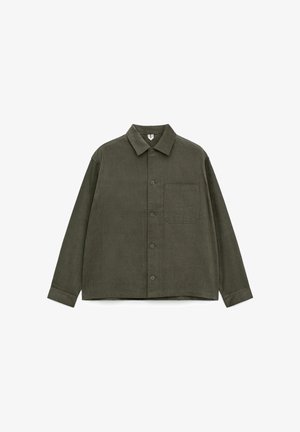 Olive green corduroy shirt jacket with a collared neckline, front buttons, and a chest pocket. Features long sleeves and a straight hem.