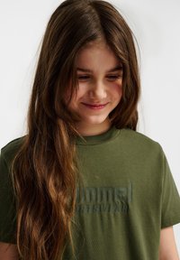 Olivewgreenowy T-shirt z bawełny z fakturowanym nadrukiem logo w ciemniejszym odcieniu. Krótkie rękawy i ściągacz przy okrągłym dekolcie.