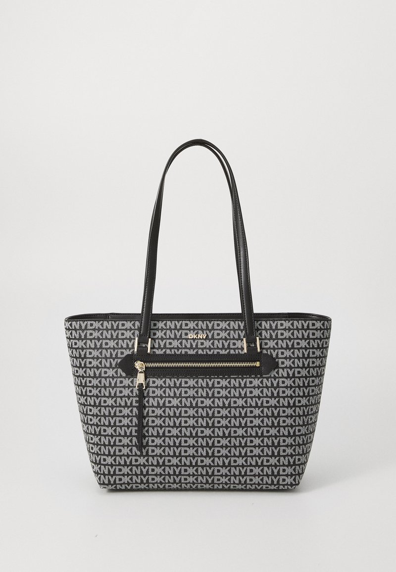 Black and gray tote bag featuring repeating DKNY logo pattern, two long handles, zippered pocket with gold hardware, and structured shape.