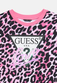 Pink and black leopard print sweatshirt featuring a triangular black logo with "GUESS U.S.A." and a pink "love" detail.