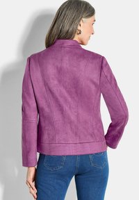 Veste en suède violet au design ajusté, dotée d'un col haut et de détails de couture. Surface texturée ; manches longues et longueur cropped.