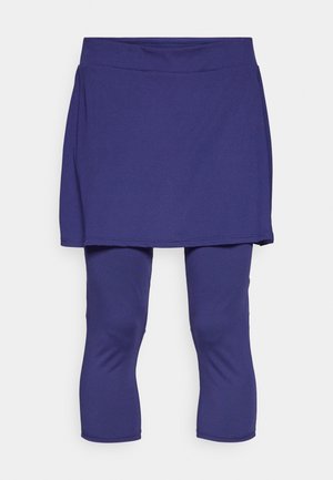 Fioletowa spódnica sportowa z dopasowanym spodem. Wykonana z oddychającego materiału, charakteryzuje się gładkim pasem i leginsami do kolan o elastycznej strukturze.