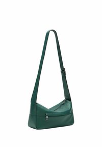 Zielona skórzana torba na ramię z regulowanym paskiem i dwoma widocznymi zamykanymi na zamek kieszeniami, przedstawiona na białym tle.