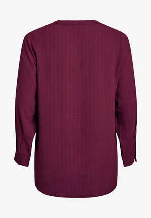 Burgundi värvi pikad varrukad särk, millel on tekstuuriga soonikpattern, ümmargune kaelus ja nööbide detailid varruka otsas.