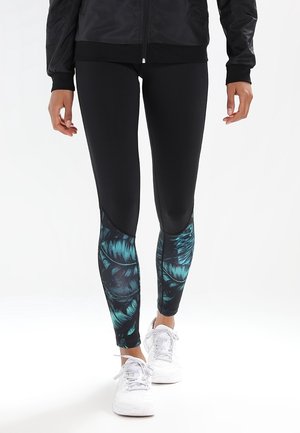 Schwarze Leggings mit einem strukturierten, grün-blauen Blättermuster an den Seiten. Hergestellt aus dehnbarem Material, konzipiert für Komfort und Bewegungsfreiheit.