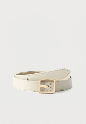 Ceinture en cuir crème avec boucle carrée dorée, roulée sur un fond clair uni.