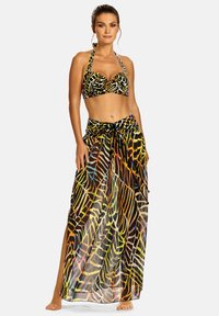Zestaw bikini z halterem, ozdobiony kolorowym nadrukiem zwierzęcym. W komplecie przejrzysta maks spódnica z wiązaniem w talii i szczegółami w postaci rozcięć.