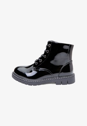 Black patent leather ankle boots with a rounded toe, lace-up front, rubber sole, and decorative silver studs along the sole edge.