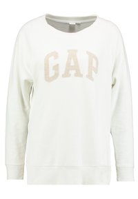 Sudadera blanca hecha de una tela suave, con un cuello acanalado, mangas largas y un logo en relieve en beige de "GAP" en el pecho.