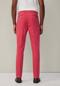 Rosa Leinenhosen mit einer taillierten Passform, zwei Gesäßtaschen und einer glatten Textur. Verfügen über Falten und ein gerades Bein-Design.