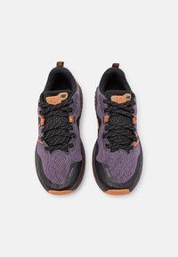 Scarpe sportive viola e nere con tomaia in rete, dettagli testurizzati e accenti arancioni. Presentano lacci neri e una punta a contrasto.