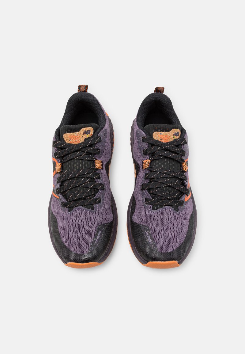 Lila und schwarze Sportschuhe mit Mesh-Obermaterial, strukturierten Details und orangefarbigen Akzenten. Verfügt über schwarze Schnürsenkel und eine kontrastierende Zehenkappe.