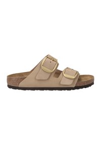 Sandale beige à deux brides avec une tige en suède doux, des boucles en métal doré, un semelle intérieure en liège et une semelle en caoutchouc texturé.