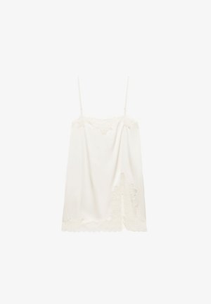 Witte satijnen camisole met dunne verstelbare bandjes en geschulpte kanten rand aan zoom en halslijn, met een kanten bloemendetail aan één kant.