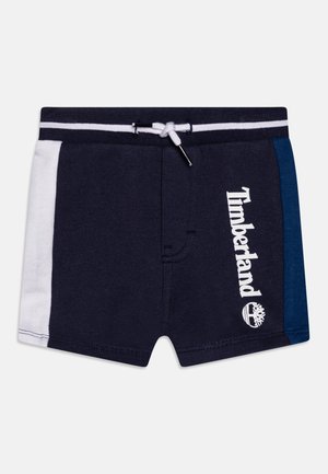 Shorts de bain bleu marine avec panneaux latéraux blancs et bleus, taille élastique, cordon de serrage et logo Timberland imprimé en blanc.