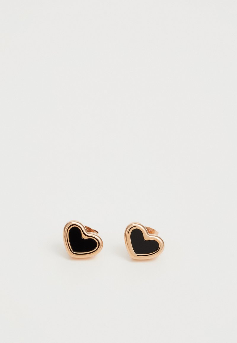 Boucles d'oreilles en forme de cœur en métal rose doré avec un revêtement en émail noir. Texture lisse avec un design à contours superposés. Petite taille adaptée à un port quotidien.