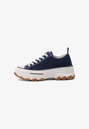 Sneaker basso blu navy con lacci bianchi, suola spessa bianca, suola esterna marrone testurizzata e linguetta posteriore per facilitare la calzata.