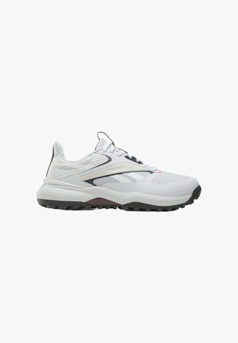 Chaussure de sport blanche et grise Reebok avec semelle texturée, dessus en mesh et fermeture à lacets, vue de profil sur fond blanc.