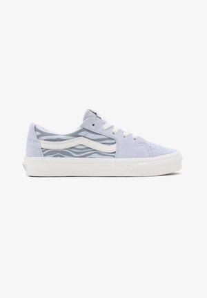 Zapatilla baja con ante gris claro, rayas de cebra gris y blancas, franja lateral blanca, cordones blancos y suela de goma blanca.