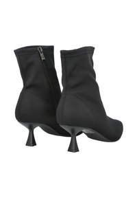 Botines negros para tobillo hechos de tela suave, con cierre de cremallera y tacón cónico. El diseño es elegante, con una textura lisa y costuras mínimas.