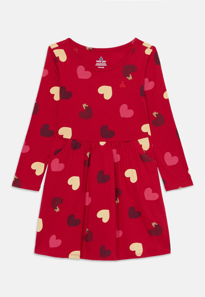 Red long-sleeve dress featuring a heart pattern in various colors and small bear accents, with a flared skirt and side pockets.