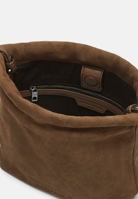 Borsa a mano in suede marrone con chiusura magnetica e tasca interna con zip, dotata di rifiniture in pelle e un'etichetta con logo.
