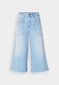 Světle modré džíny s vysokým pasem a širokými nohavicemi, zkrácené, s velkými předními klopovými kapsami a zapínáním na knoflík v pase.