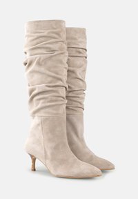 Bocanci bej din suede artificial, cu un design lejer, vârful ascuțit și un toc subțire de înălțime medie. Textură netedă cu detalii din țesătură plisată.