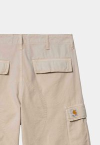 Pantalones cargo beige con dos bolsillos de parche, detalles reforzados en las rodillas y un parche de marca tejido. Fabricados con un tejido resistente, presentan un corte recto.