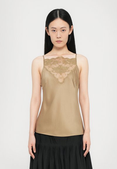 Camisole en soie marron clair avec un panneau en dentelle au niveau de l'encolure. Fines bretelles, texture lisse et silhouette semi-ajustée.