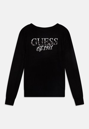 Czarna koszula z długim rękawem z nadrukiem "GUESS" i "Est. 1981" z przodu, z małymi odblaskowymi kropkami na nazwie marki.