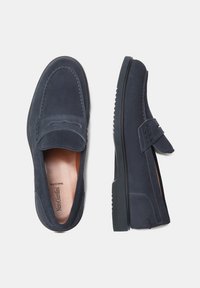 Navyblaue Wildleder-Slipper mit flacher Gummisohle, verziert mit gestickten Details und einer runden Zehenpartie. Mit einem Vorderriemen und Logo im Inneren akzentuiert.
