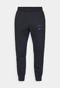 Črne tapered trenirke z elastičnim pasom in manšetami, z diskretnimi logotipi Spurs in Nike na zgornjem stegnu.