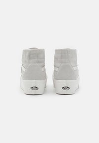 Hochschnittige Sneakers aus hellgrauem Wildleder mit einer gesteppten Textur. Mit weißen Seitenstreifen und einer weißen Gummisohle ausgestattet. Logo auf der Ferse.