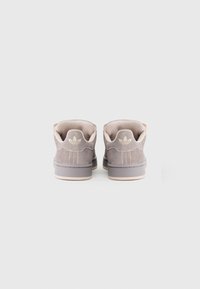 Sive semiš superge z rožnatimi poudarki, okrogla zadnja stran, mehka podloga in vtisnjen logotip. Ravna svetla gumijasta podplata. Zadnji pogled.