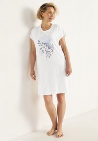 Hvid bomulds natkjole med et blomsterlinien tegning i blå. Korte ærmer, løs pasform, knælængde design. Glat tekstur.