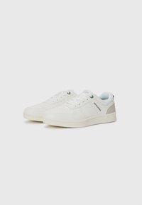 Zapatillas blancas con acentos y cordones en gris claro, que muestran un diseño limpio adecuado para el uso casual. Presenta detalles perforados en los lados.