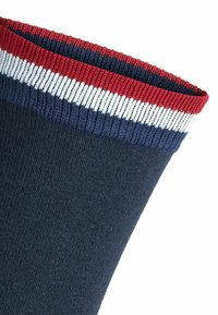 Tumedat sinised sokid, millel on tekstureeritud pind. Ribitud ülaserv on adornatud punaste, valgete ja tumedate siniste triipudega. Pehme, elastne materjal mugavuse tagamiseks.