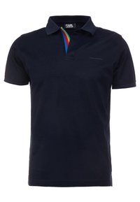 Marinblå polo med krage, prydd med en färgglad rand längs knäppningen; tillverkad av ett mjukt tyg; diskret logotypdetalj på bröstet.