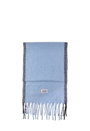 Bufanda azul clara con un borde gris oscuro, textura suave y extremos con flecos. Incluye una pequeña etiqueta de logo en blanco y negro.