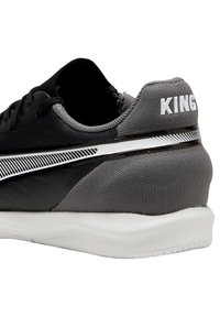 Czarno-szary but sportowy z gładkiego materiału, teksturowanym obcasem, białym logo "KING" oraz błyszczącym srebrnym akcentem wzdłuż boku.